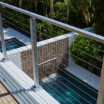 cable railing surface mount posts overlooking a beautiful pool in a Florida condo