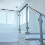 minimalistic glass system surface mount brushed stainless posts and rail angle to level